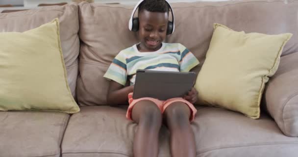 African American Boy Enjoys Digital Content Home Using Tablet Engaged — Stock Video