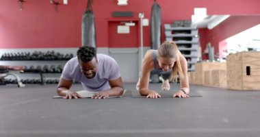 Spor salonunda ahşap döşeme yapan uygun bir çift. Egzersiz rutinleri güç ve ortaklığı vurguluyor, ağır çekim..