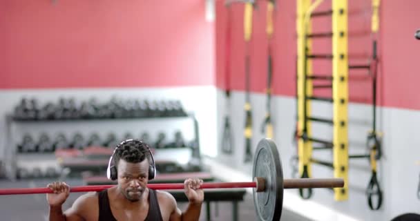 체육관에서 체중을 올리는 아프리카계 미국인 남자에 초점과 결정은 슬로우 모션으로 — 비디오