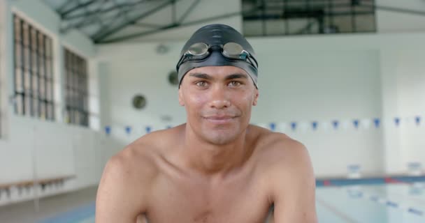 年轻的伯利兹男子运动员在游泳池里对着摄像机微笑 他自信的表情表明 他是个熟练的游泳选手 随时准备参加比赛 动作缓慢 — 图库视频影像