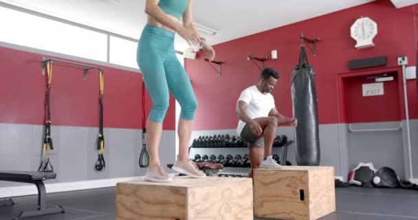 年轻的白人女子和非洲裔美国男子在体育馆表演跳伞 他们的运动在健康的环境中表现出力量和敏捷 动作缓慢 — 图库视频影像