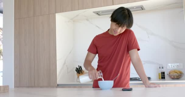아시아 집에서 시리얼의 그릇에 우유를 현대적인 부엌에서 건강한 슬로우 모션을위한 — 비디오