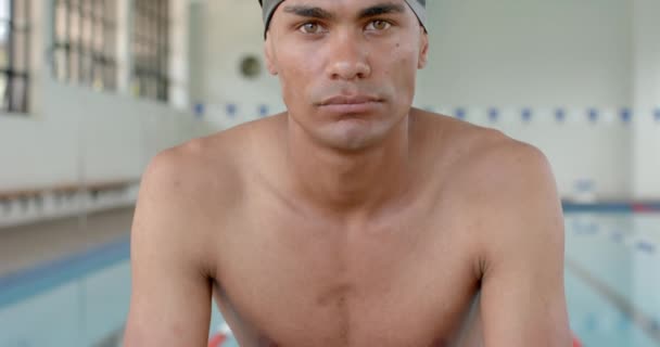 年轻的伯利兹男子运动员准备在游泳池游泳 他专注的表情传达了室内环境中的决心和运动能力 动作缓慢 — 图库视频影像