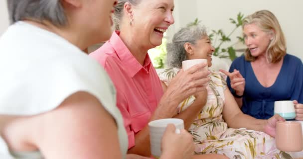 高级不同群体的妇女在家里分享欢笑 长生不老的女人和白种人的朋友在一起 享受着片刻的快乐和放松 缓缓的运动 — 图库视频影像