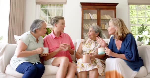 资深亚洲妇女和两名资深白人妇女在家里聊天很开心 他们与咖啡共度了一段轻松的时光 营造了温暖 慢动作的氛围 — 图库视频影像