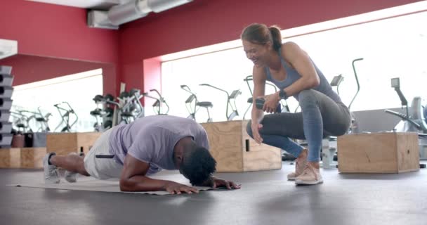 Fit Afroamerikaner Macht Eine Planke Fitnessstudio Mit Trainer Mit Kopierraum — Stockvideo