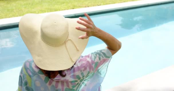 Μια Λευκή Γυναίκα Απολαμβάνει Μια Ηλιόλουστη Μέρα Δίπλα Στην Πισίνα — Αρχείο Βίντεο