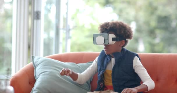 Африканський Американський Хлопчик Сидить Дивані Використовуючи Гарнітуру Торкаючись Віртуального Екрану — стокове відео
