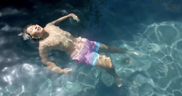 Tiener Aziatische Jongen Drijft Rustig Helder Zwembadwater Sereniteit Omhult Als — Stockvideo