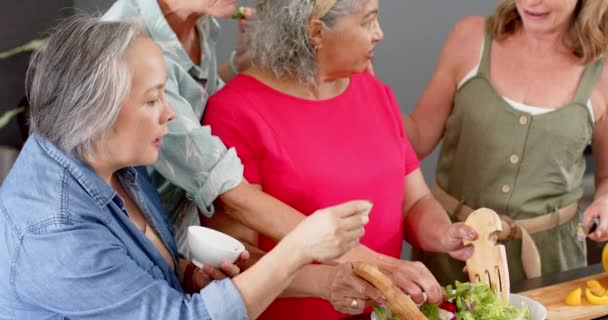 家庭で料理教室に従事する女性のシニア多様なグループ 彼らは食事の準備 学習とコラボレーションの瞬間を共有することに焦点を当てています スローモーション — ストック動画
