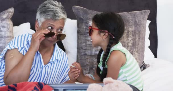 Biracial Asszony Unokája Napszemüveget Próbálnak Ágyon Ülnek Egy Játékos Pillanaton — Stock videók