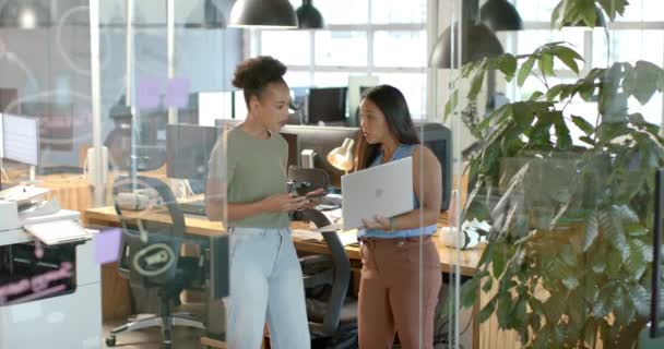 若いアフリカ系アメリカ人女性が現代のオフィスで女性と話し合っている コンピュータやオフィス工場に囲まれた会話や仕事 スローモーションに取り組んでいます — ストック動画