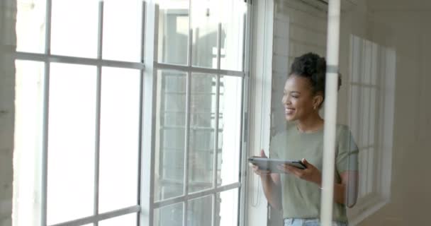 Młoda Afroamerykanka Stoi Przy Oknie Przestrzenią Kopiowania Używa Tabletu Pracy — Wideo stockowe