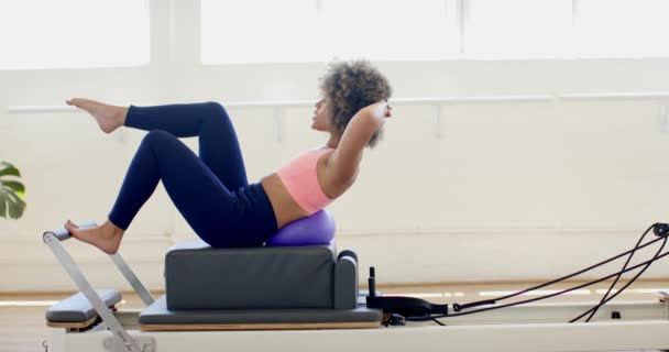 Mladá Biracial Žena Cvičení Pilates Reformátor Jasném Studiu Její Soustředěný — Stock video