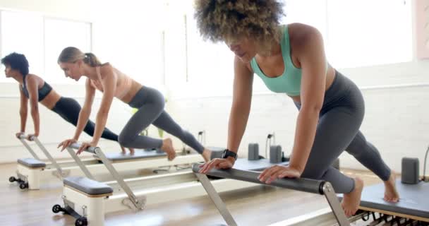 Unge Kvinner Leder Pilates Klasse Lyst Studio Reformator Hun Demonstrerer – stockvideo