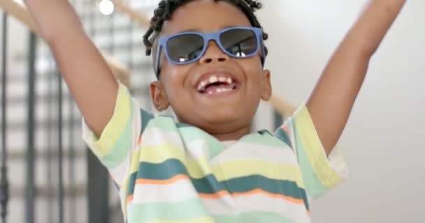 Afrikansk Amerikansk Gutt Med Lyst Smil Bærer Blå Solbriller Stripete – stockvideo
