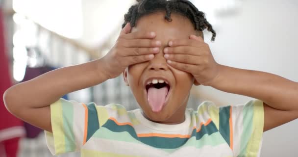 Afrikkalainen Amerikkalainen Poika Peittää Silmänsä Käsillään Hymyillen Leveästi Kotona Sisätiloissa — kuvapankkivideo