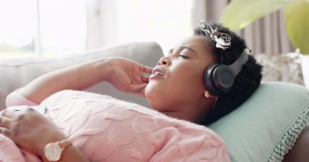 African American Woman Relaxes Headphones Couch Home She Appears Peaceful — Stock Video