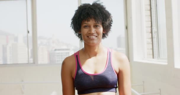 Biracial Žena Kudrnatými Černými Vlasy Usmívá Světlé Místnosti Fitness Studiu — Stock video
