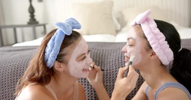 Two Young Biracial Female Friends Enjoy Skincare Routine Wearing Facial — Stock Video