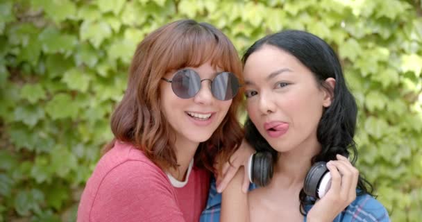 Melez Kız Arkadaş Birlikte Gülüyor Biri Güneş Gözlüğü Kulaklık Takıyor — Stok video