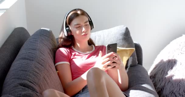 Έφηβη Καυκάσια Απολαμβάνει Μουσική Στα Ακουστικά Της Ενώ Χρησιμοποιεί Ένα — Αρχείο Βίντεο