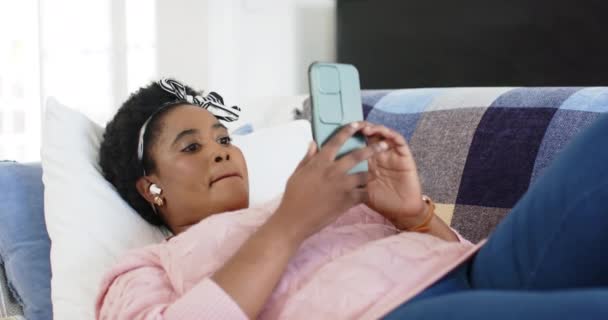 African American Woman Enjoys Music While Relaxing Couch Home She — Stock Video