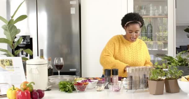 부엌에서 향신료 용기를 흔드는 아프리카계 미국인 여성의 재생합니다 신선한 재료로 — 비디오