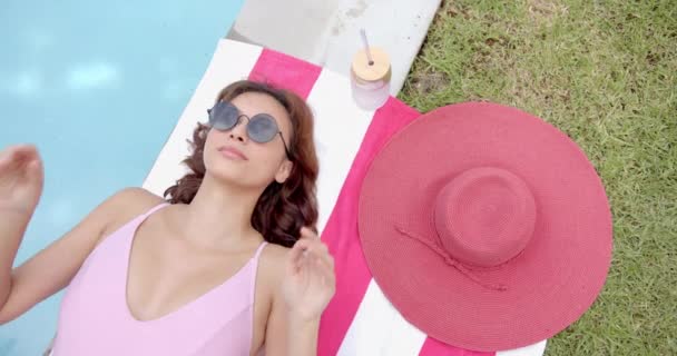 Una Mujer Traje Baño Rosa Relaja Junto Piscina Ajustando Sus — Vídeo de stock