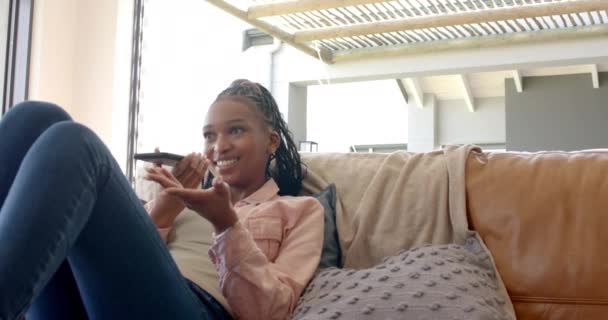 Μια Νεαρή Αφρο Αμερικανίδα Χαλαρώνει Έναν Καναπέ Στο Σπίτι Μιλώντας — Αρχείο Βίντεο