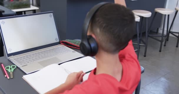 Ein Birassischer Junge Mit Kopfhörern Studiert Einem Laptop Einem Klassenzimmer — Stockvideo