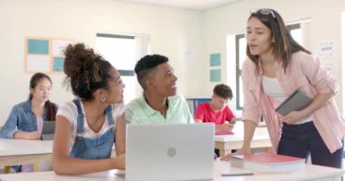 Çeşitli gençler lisede parlak bir sınıfta bir dizüstü bilgisayarın etrafında toplanırlar. Ekranda kısa saçlı melez bir oğlan gülümserken, kıvırcık saçlı melez bir kız ve genç bir kadın tartışıyorlar..