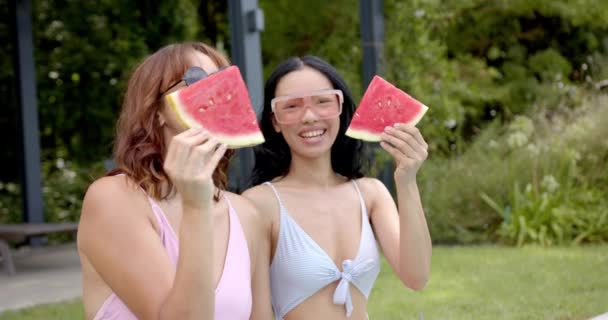 Two Young Biracial Female Friends Enjoy Watermelon Slices Outdoors Playfully — Stock Video