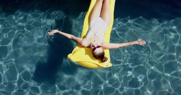 Genç Beyaz Bir Kız Havuzda Sarı Bir Şamandırada Güneş Gözlüğü — Stok video