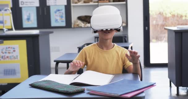Ein Birassischer Junge Mit Einem Headset Sitzt Einem Schreibtisch Mit — Stockvideo