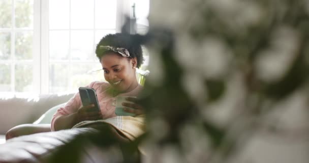 Mujer Afroamericana Sonriendo Teléfono Sosteniendo Una Taza Casa Ella Está — Vídeos de Stock