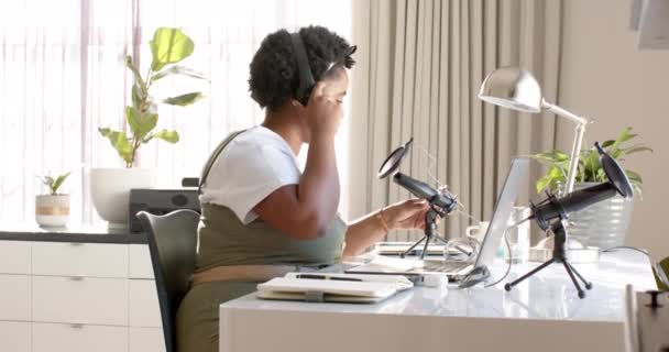 아프리카계 미국인 여성은 집에서 오피스에서 캐스트를 녹음합니다 그녀는 헤드폰을 착용하고 — 비디오