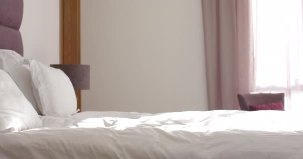 Ένα Τακτοποιημένο Κρεβάτι Λευκά Λινά Είναι Στο Επίκεντρο Ένα Πορφυρό — Αρχείο Βίντεο