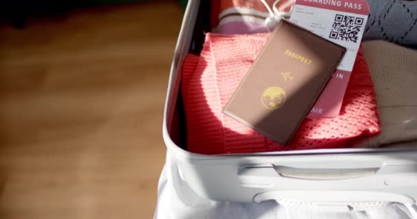 パスポートと搭乗券は オープンスーツケースの服の上にあります シーンは旅行の準備を提案し 旅行の必需品が詰まり 準備ができて スローモーション — ストック動画