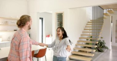 Genç bir çift dans ediyor ve evdeki modern bir mutfakta eğleniyor. Kız arkadaşının uzun kahverengi saçları ve erkek arkadaşının sakalı ve at kuyruğu var.