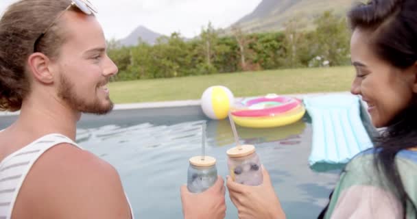 Een Jong Biraciaal Echtpaar Geniet Van Drankjes Bij Het Zwembad — Stockvideo