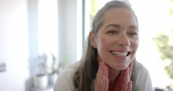 Een Volwassen Blanke Vrouw Lacht Hartelijk Raakt Haar Gezicht Aan — Stockvideo