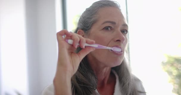 Dojrzała Biała Kobieta Skupia Się Myciu Zębów Długie Siwe Włosy — Wideo stockowe