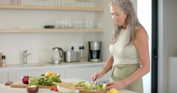 Dojrzała Biała Kobieta Przygotowuje Sałatkę Kuchni Domu Długie Siwe Włosy — Wideo stockowe