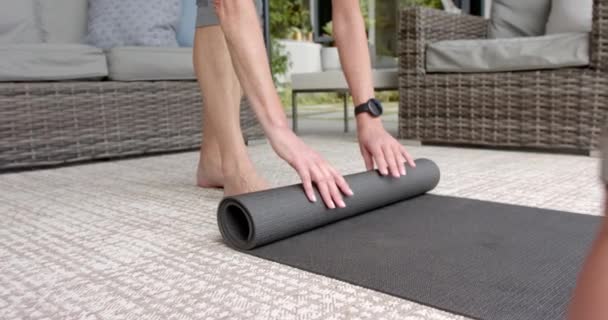 Una Persona Está Enrollando Una Esterilla Yoga Después Una Sesión — Vídeos de Stock