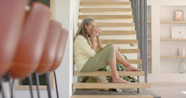 Olgun Beyaz Bir Kadın Evdeki Merdivenlerinde Bir Fincan Çay Içiyor — Stok video