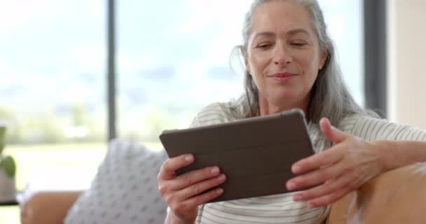 Een Volwassen Blanke Vrouw Verdiept Haar Tablet Kopieerruimte Bank Thuis — Stockvideo