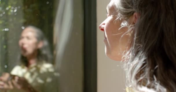 Una Mujer Caucásica Madura Mira Por Una Ventana Casa Luz — Vídeos de Stock