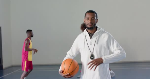 Entrenador Afroamericano Está Pie Con Confianza Con Baloncesto Detrás Diverso — Vídeos de Stock