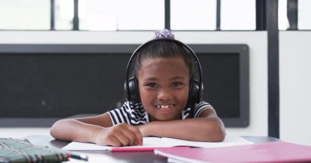 Шкільному Класі Молода Афроамериканська Дівчина Носить Навушники Неї Яскрава Посмішка Стоковий Відеоролик